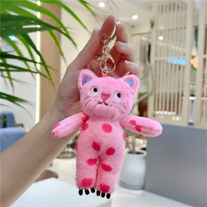 Detailed shot of pink plush cat keychain with polka dots and golden metal lobster clasp