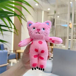 Pink polka dot cat plush keychain accessory shown being held in hand for scale