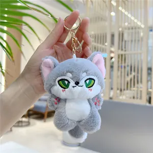 Close-up of a plush fox keychain held in hand showing the soft fur and golden metal clasp