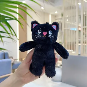 Close-up of black plush cat keychain with pink heart nose and red-blue embroidered ears