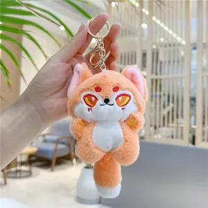 Close-up of cute plush fox keychain with orange fur and golden metal clasp detail
