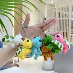 Assorti kleurrijke pluche schildpad sleutelhangers in verschillende zachte stijlen in de hand