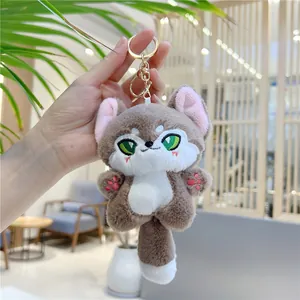 Detail of cute plush fox keychain with green eyes and golden lobster clasp closure