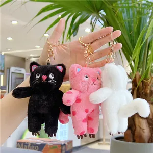 Detailed close-up of cute plush cat keychains in black, pink polka dots and white colors