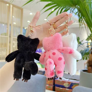 Plush cat keychains in black, white, and polka dot pink with golden metal lobster clasps