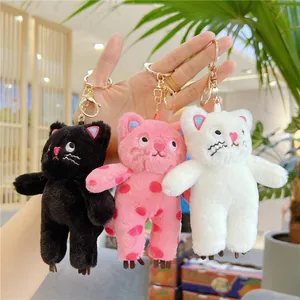 Three plush cat keychains in black, pink polka dots and white with gold metal clips