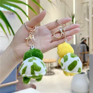 Gedetailleerde weergave van groene en gele pluche schildpad sleutelhangers met metalen clip