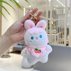 Detail of pink bunny plush keychain with strawberry embroidery bib and golden metal hook