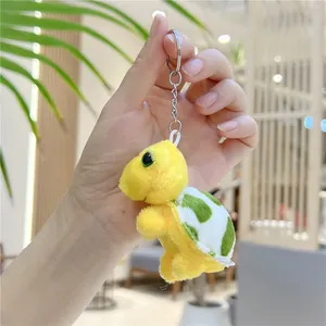 Detail van de gele pluche schildpad sleutelhanger met groene ogen en een stippenpatroon