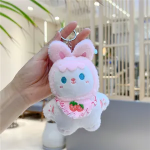 Close-up of cute pink and white bunny plush keychain with strawberry lace bib detail