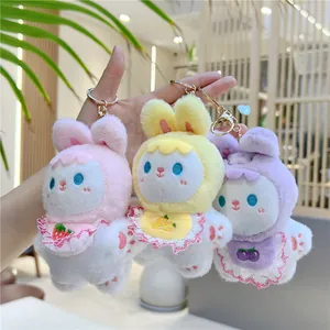 Three cute plush rabbit keychains in pink, yellow, and purple with lace bibs and metal hooks