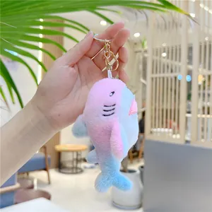 Detailed macro view of a colorful rainbow plush shark keychain held in hand for scale