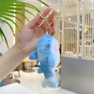 Detail of soft blue and white plush shark keychain with high-quality golden metal clasp