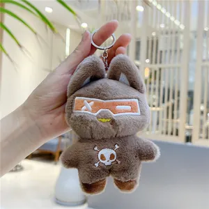Detail eines Plüsch-Katzenanhängers mit orangefarbener Brille und gesticktem Totenkopf