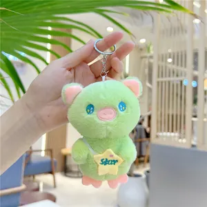 Detail of mint green plush pig charm with star bag and metallic keychain ring