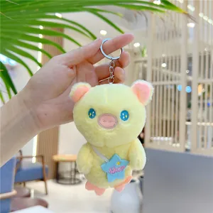 Close-up of yellow plush pig keychain with star bag and metal ring attachment