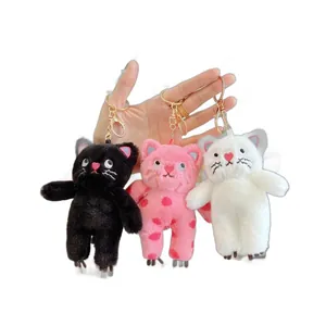 Three plush cat keychains in black, white, and polka dot pink with metal lobster clasps