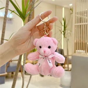 Gros plan du porte-clés ours en peluche rose avec ruban love et mousqueton doré