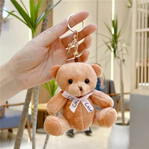 Détail de porte-clés ours en peluche marron clair avec ruban Love et mousqueton doré