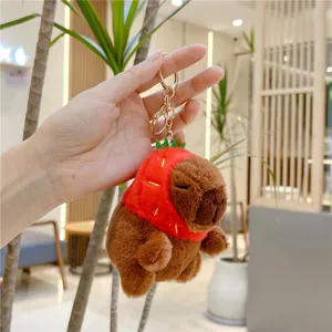 Cute Capybara plush keychain wearing a red strawberry hat with golden metal clasp