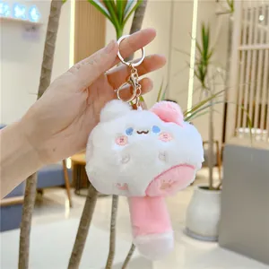 Detailed macro view of plush cat pendant featuring soft embroidery and a gold metal clasp