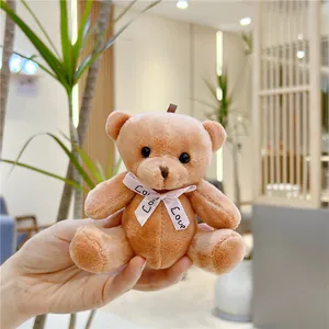 Gros plan du porte-clés ours en peluche marron clair avec nœud en soie Love rose
