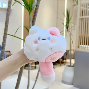 Close-up of a plush white cat keychain with pink details and soft embroidered face