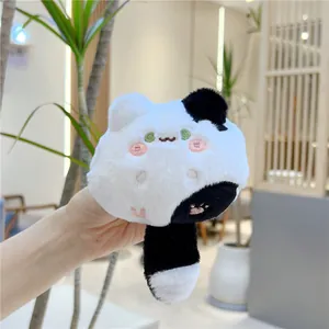 Detailed close-up of fluffy black and white plush cat hair accessory with embroidery