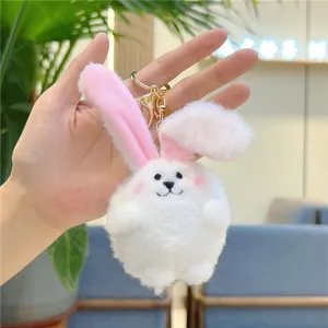 Dettaglio del portachiavi a coniglio in peluche bianco con orecchie rosa e pelliccia morbida