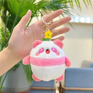 Close-up of pink panda plush keychain with yellow flower detail and embroidery