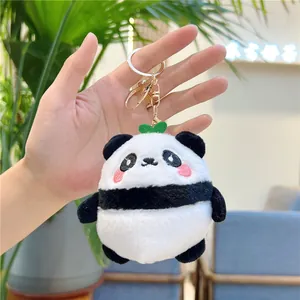 Close-up of plush panda keychain with soft fur, pink cheeks, and gold metal clasp