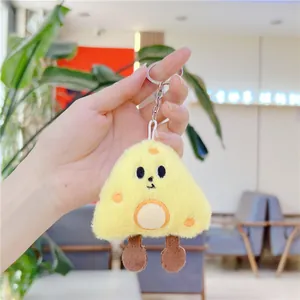 Close-up of a plush yellow cheese keychain with embroidered face and brown legs