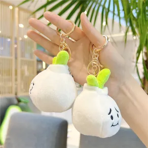 Cute garlic plush keychain with embroidery face and green leaves in hand display