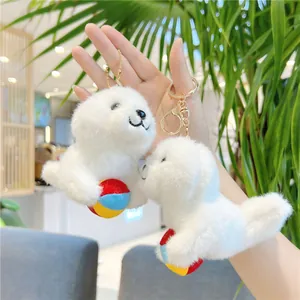 Set of two white plush seal keychains holding colorful balls for bag decoration