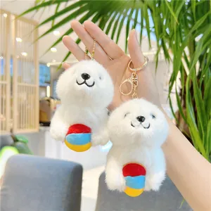 Set of two cute white plush sea lion keychains holding colorful balls for bags