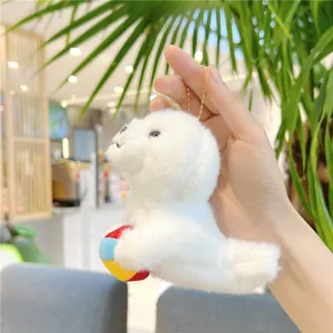 Detailed view of white plush seal charm holding a colorful ball with gold bead chain