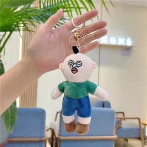 Detailed view of an ugly-cute plush keychain with green shirt and blue shorts