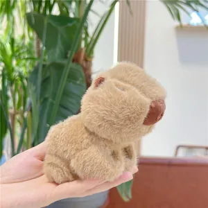Close-up of a soft plush capybara keychain with fluffy fur texture in hand