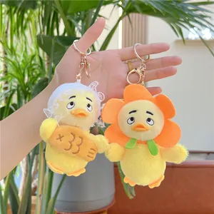 Nahaufnahme süßer Plüsch-Enten-Anhänger mit Spitzenhut, Blumenkragen und Goldhaken