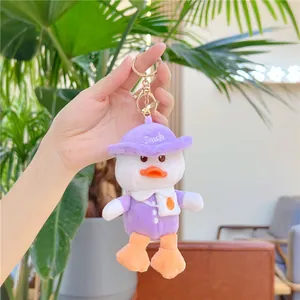 Cute plush duck keychain with purple hat and outfit, hanging from a metal lobster clasp