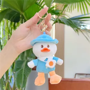 Plush duck keychain wearing a blue sailor outfit and fried egg bag on a hand