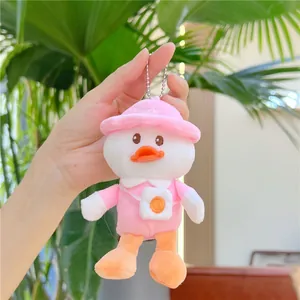 Detail of cute plush duck keychain with pink hat and egg bag held in hand