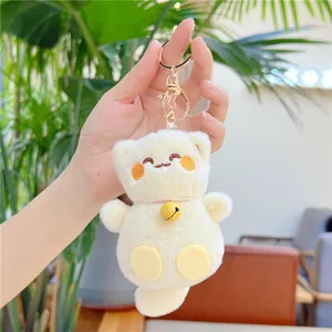 Gros plan du porte-clés chat en peluche crème avec clochette dorée et fermoir