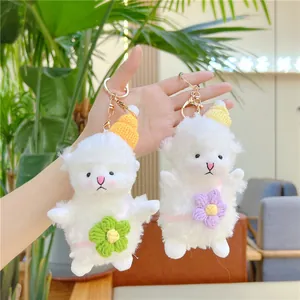 Cute plush sheep keychain set with knitted hats and golden rings held by a hand