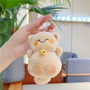 Gros plan d'un porte-clés chat porte-bonheur en peluche avec grelot jaune et chaîne
