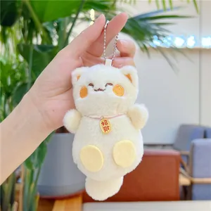 Gros plan du pendentif chat de fortune en peluche avec une médaille porte-bonheur