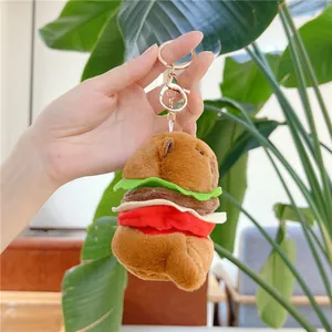 Detail of cute capybara burger plush keychain with metallic rose gold lobster clasp