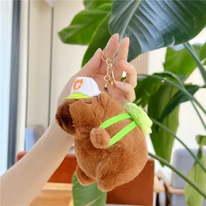 Adorable plush Capybara keychain with green cap and mini backpack on a golden hook
