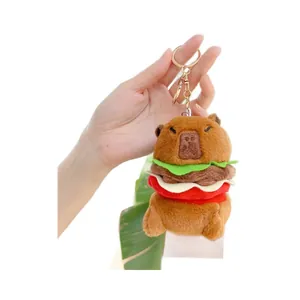 Adorable capybara hamburger plush keychain with premium golden metal clasp held in hand