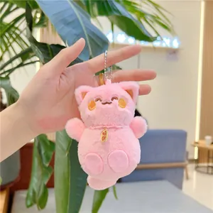 Dettaglio del portachiavi gatto di peluche rosa con campanellino dorato e ricamo